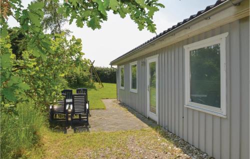 two chairs sitting on a patio next to a house at Holiday Home Illeris Farsø Ix in Hvalpsund