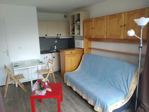 ein kleines Zimmer mit einem Bett und einem Tisch mit Blumen in der Unterkunft Le Plein Soleil 2 510 in Orcières