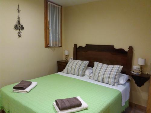 a bedroom with a green bed with two towels on it at Ventallols in Tarragona