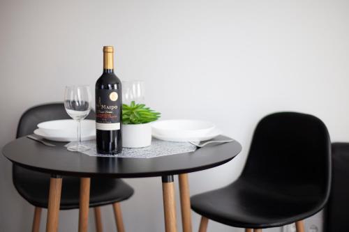 Oak house apartments في كاوناس: طاولة سوداء مع زجاجة من النبيذ وكأس