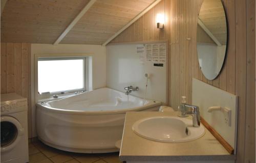 La salle de bains est pourvue d'une grande baignoire et d'un lavabo. dans l'établissement 2 Bedroom Pet Friendly Home In Vejby, à Vejby