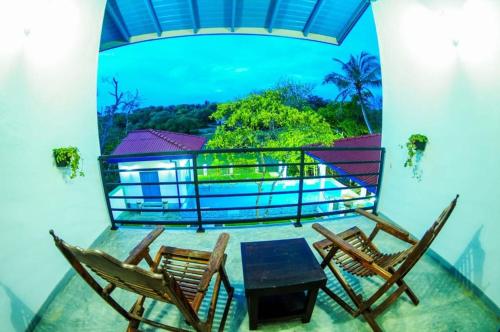 a room with two chairs and a table on a balcony at Seth Villa by Magampura Resorts in Tangalle