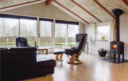 un soggiorno con 2 sedie e una stufa a legna di Three-Bedroom Holiday Home In Hejls a Hejls