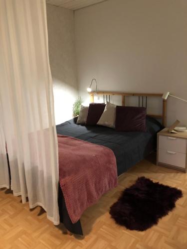 a bedroom with a bed and a rug on the floor at Joutiaisentie I 55 Forest apartment in Joutsa