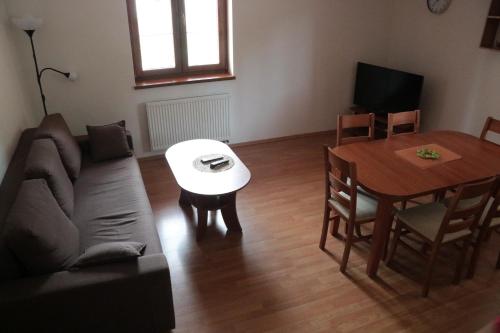 uma sala de estar com um sofá e uma mesa em Apartmány Olympia em Železná Ruda