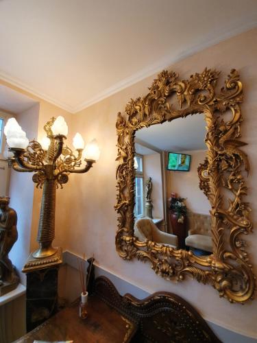 a large gold mirror on a wall in a room at Esos Hotel Quelle in Bad Ragaz