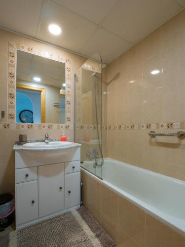 a bathroom with a sink and a tub and a mirror at Apartament Sofia in Mar de Cristal