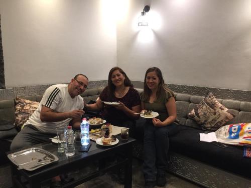 a group of people sitting on a couch eating food at H100 Pyramids View in Giza