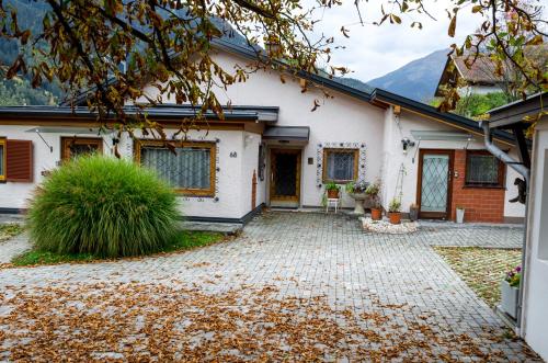 a white house with a driveway at Ferienwohnungen Angermaier in Flattach