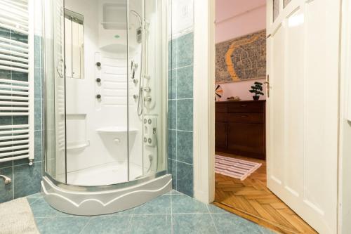 uma casa de banho com um chuveiro e uma porta de vidro em Szasz Buda Villa Apartment next to Buda Castle district em Budapeste