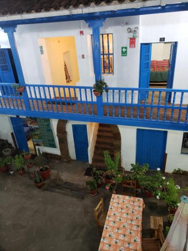 un edificio azul y blanco con balcón y mesas en Hospedaje Euro's De San Blas, en Cusco
