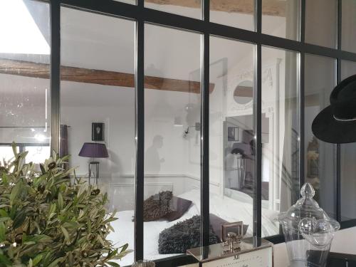 um quarto com uma janela de vidro com uma cama em Loft avec spa Lourmarin em Lourmarin