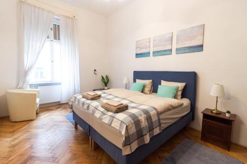Schlafzimmer mit einem großen Bett mit blauem Kopfteil in der Unterkunft Szasz Buda Villa Apartment next to Buda Castle district in Budapest