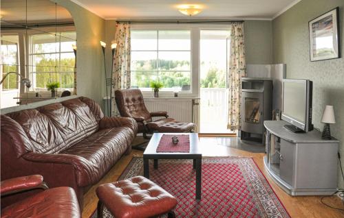 a living room with a leather couch and a tv at 2 Bedroom Lovely Home In Sunne in Sunne
