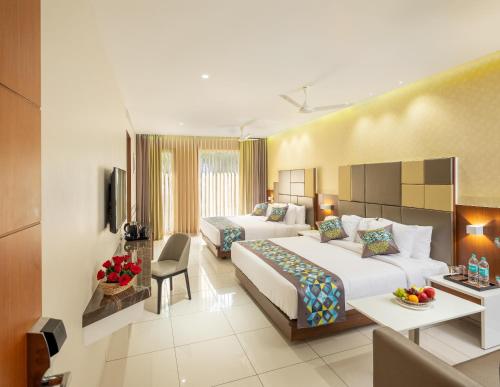 Habitación de hotel con 2 camas y sala de estar. en Hotel Divine Fort en Palani