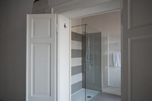 a white bathroom with a shower and a glass door at Residenza Giulio Romano in Mantova