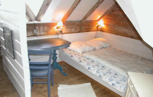 BolilmarkにあるBeautiful Home In Rm With 3 Bedroomsのテーブルとデスクが備わる客室のベッド1台分です。