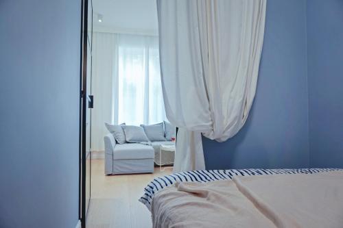 a bedroom with a bed and a chair and a mirror at Apartament Jola in Sopot