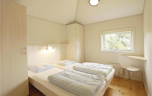 2 camas en una habitación pequeña con ventana en Mlleparken, en Gudhjem
