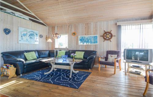 a living room with a couch and a table and a tv at Holiday Home Søndervang Hejls in Hejls