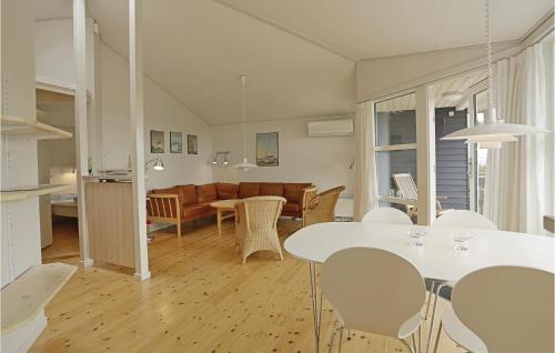 a kitchen and living room with a table and chairs at Mølleparken in Gudhjem