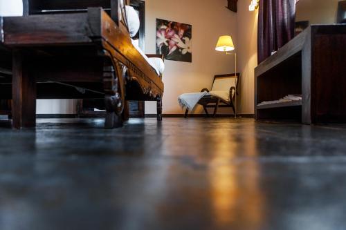 a living room with a piano and a chair at Eco Hotel Boutique & Spa Capitulo Trece - Adults Only in Maderuelo