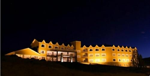 a large building is lit up at night at Hotel Las Dunas in El Calafate