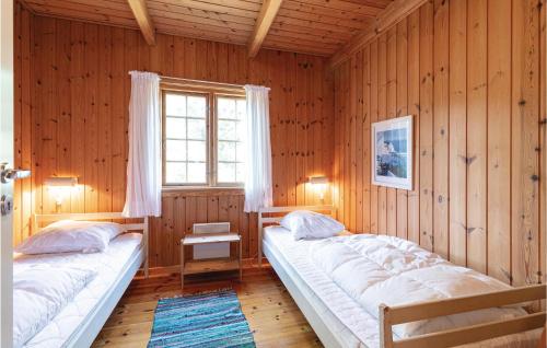 Habitación de madera con 2 camas y ventana en Grshytten en Bedegård