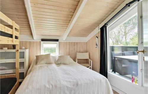 a bedroom in a tiny house with a bed and a window at Holiday Home Østparken P-625 in Otterup