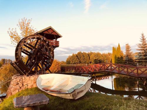 a boat sitting on the grass next to a bridge at Domek nad stawem in Działdowo