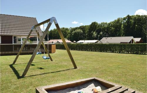a wooden swing set in a yard at Holiday Home Pøt Strandby Juelsminde Q in Sønderby