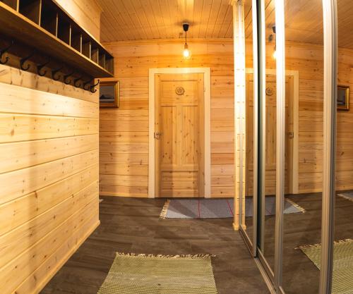 uma sauna com paredes de madeira e uma porta em Arctic Sky Lapland em Saariselka