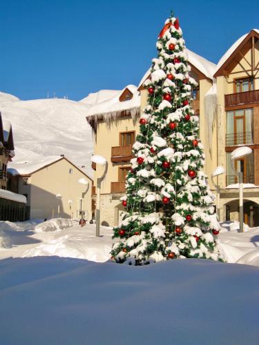 a christmas tree covered in snow in front of a building at GVC 240 New Gudauri in Gudauri
