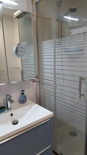une salle de bain avec une douche en verre et un lavabo dans l'établissement Villa tout confort dans résidence privée avec piscine à 500m de la plage - Climatisation, WIFI, parking, à Portiragnes