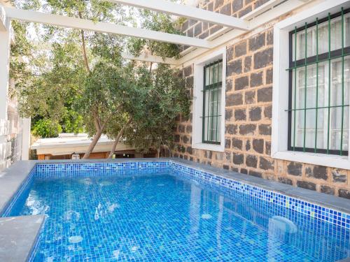 a swimming pool in front of a brick wall with windows at Berenice Winery Suites in Tiberias