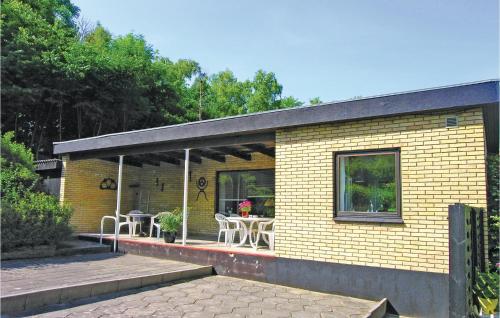 a small yellow brick house with a table and chairs at Holiday Home Kanegårdsvej in Rønne