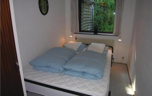 a bed with blue pillows on it in a room at Holiday Home Kanegårdsvej in Rønne