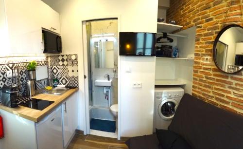 une petite cuisine avec un évier et une machine à laver dans l'établissement ★★★Studio Heart of Le Marais, Design Flat★★★, à Paris