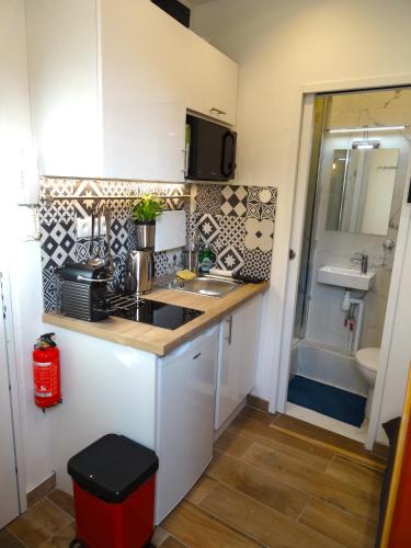 Il comprend une petite cuisine avec un évier et une salle de bains. dans l'établissement ★★★Studio Heart of Le Marais, Design Flat★★★, à Paris