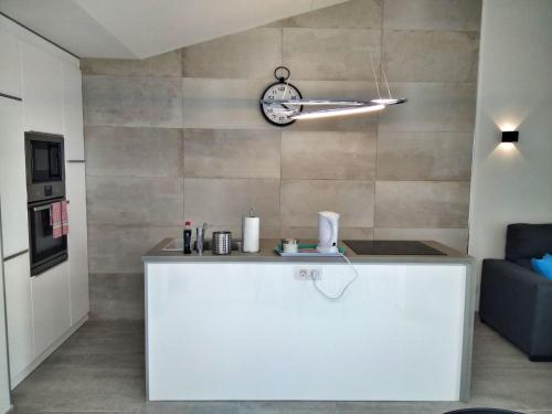 a kitchen with a counter and a clock on a wall at Luxury renevapartment island village in Adeje