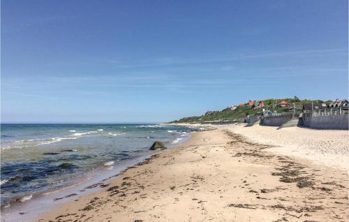 a sandy beach with the ocean on a sunny day at Rosenhavet in Vejby