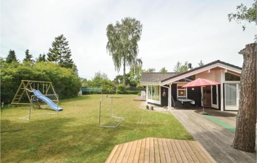 a yard with a playground and a house at Three-Bedroom Holiday Home In Vaggerlose in Marielyst