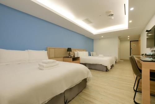 a hotel room with two beds and a kitchen at Hotel Champs Elysées in Taichung