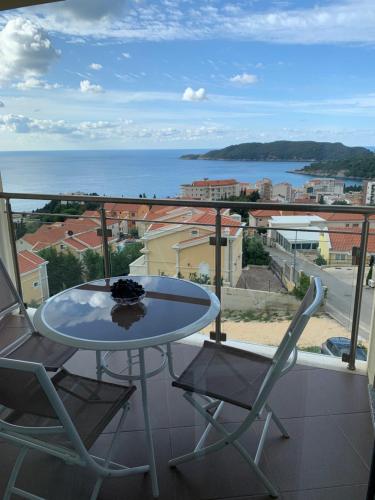 a table and chairs on a balcony with a view of the ocean at Ive Lole Ribara 38 in Becici
