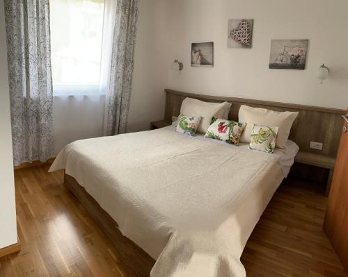 a bedroom with a white bed with pillows and a window at Ive Lole Ribara 38 in Becici