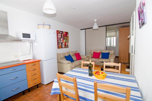 cocina y sala de estar con mesa y sillas en Casa Piedra Picuda 1, en Mogán