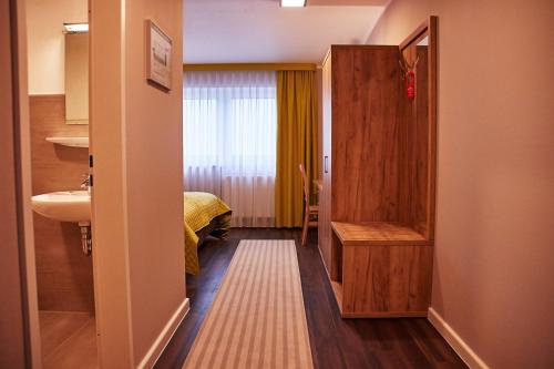 Habitación con baño con cama y lavabo. en Joos Hotel en Bergheim