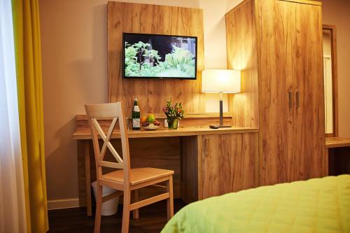 Schlafzimmer mit einem Schreibtisch mit einem Stuhl und einem Bett in der Unterkunft Joos Hotel in Bergheim