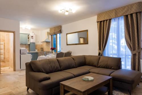 ein Wohnzimmer mit einem Sofa und einem Tisch in der Unterkunft Montana Residence in Poiana Brașov