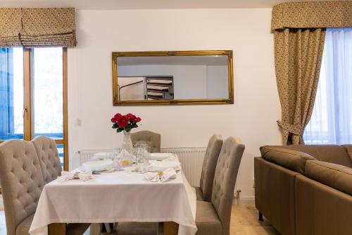 a dining room with a table and a mirror at Montana Residence in Poiana Brasov